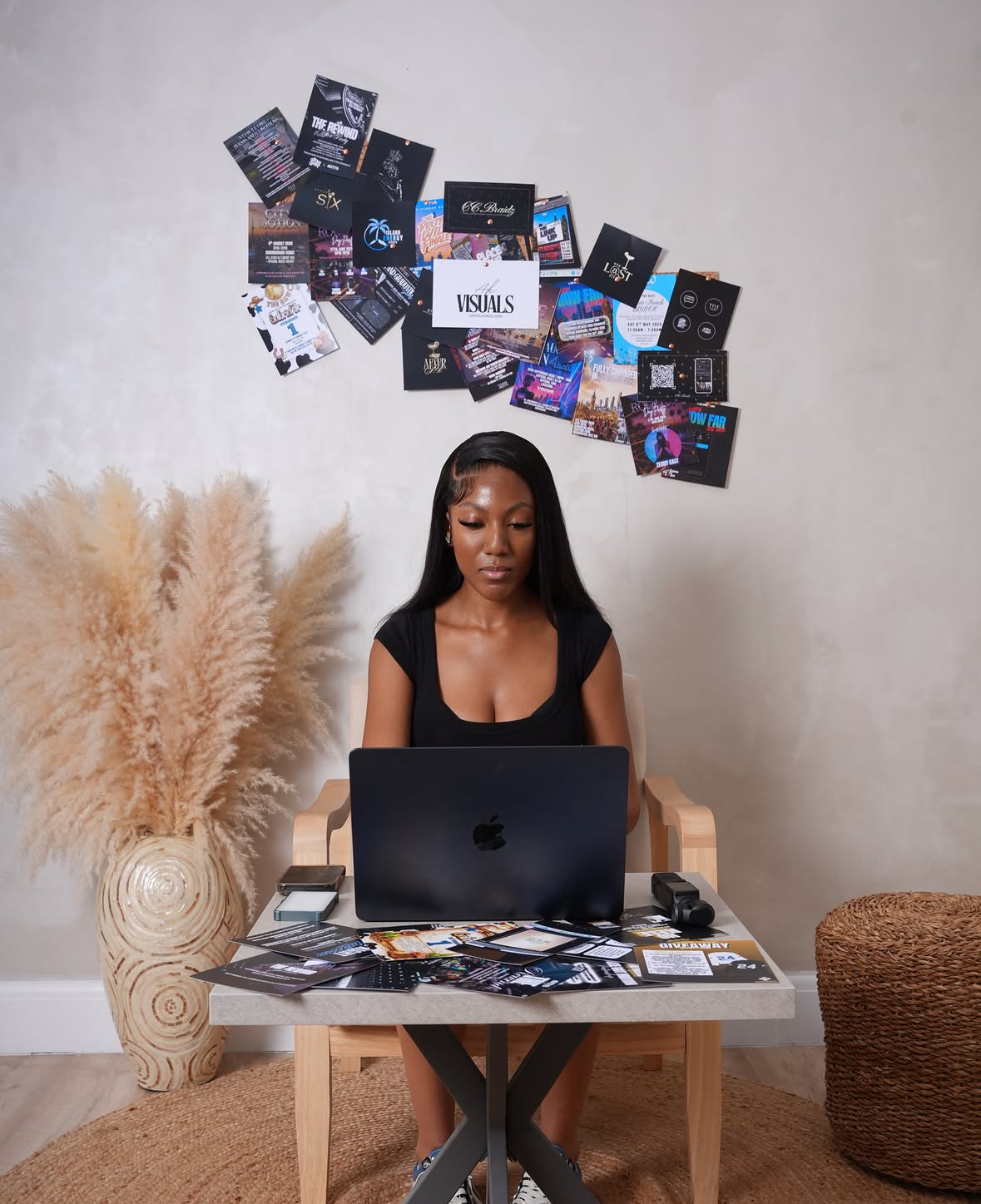 AK at her desk, surrounded by her graphic design work